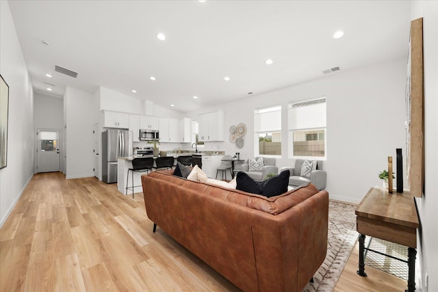 living room with light hardwood / wood-style floors and lofted ceiling