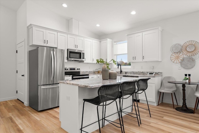 kitchen featuring white cabinetry, a kitchen island, and stainless steel appliances