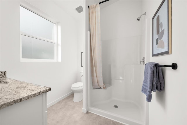 bathroom with toilet, vanity, and walk in shower