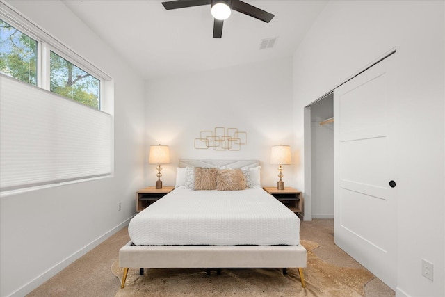 bedroom featuring ceiling fan, light carpet, and a closet