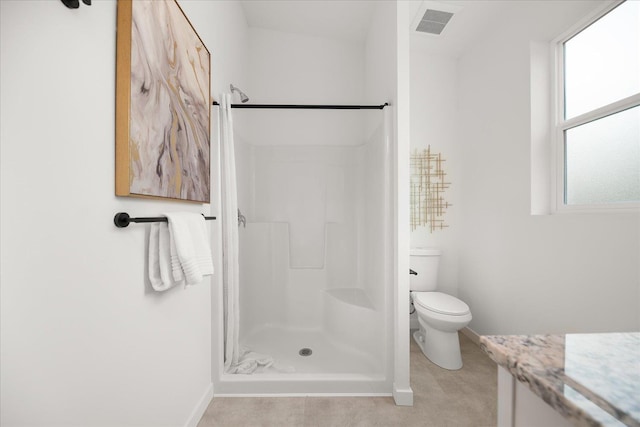 bathroom with a wealth of natural light, vanity, and walk in shower