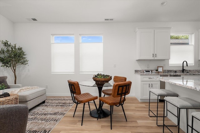 dining room with light hardwood / wood-style flooring and sink