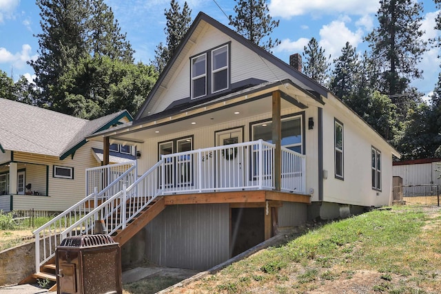 back of property featuring covered porch