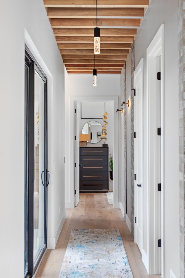 hallway featuring beam ceiling and light hardwood / wood-style floors