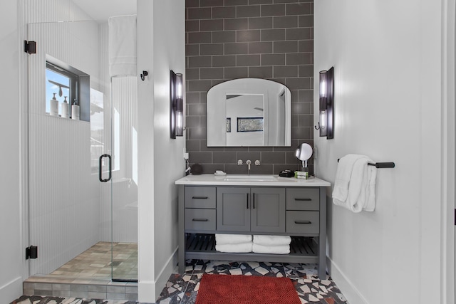 bathroom with tile patterned flooring, vanity, a shower with door, and tasteful backsplash