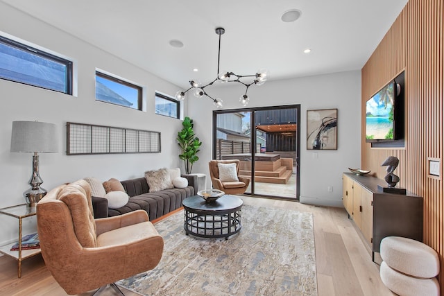 living room featuring wooden walls, a chandelier, and light hardwood / wood-style floors