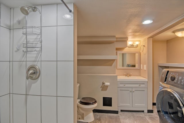 bathroom featuring washer / dryer, a shower, a textured ceiling, toilet, and vanity