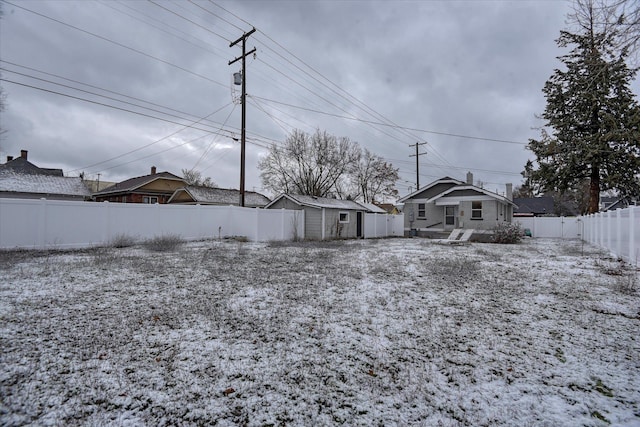 yard layered in snow featuring a storage shed