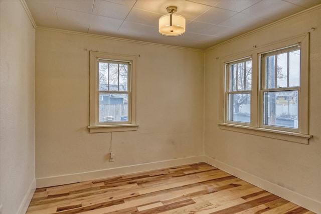 spare room featuring light hardwood / wood-style floors and ornamental molding