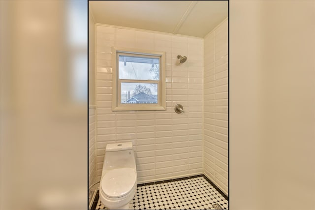 bathroom with tiled shower and toilet