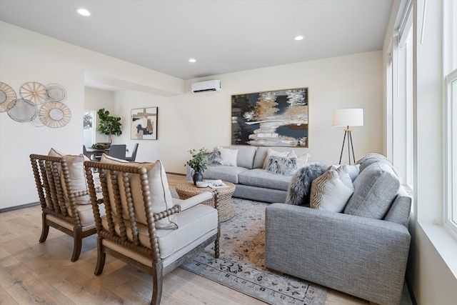 living room featuring light wood-type flooring and a wall unit AC