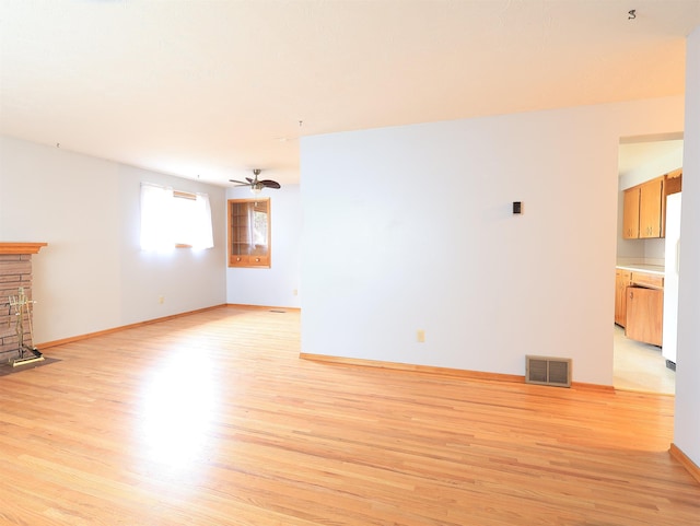 unfurnished living room featuring ceiling fan and light hardwood / wood-style flooring