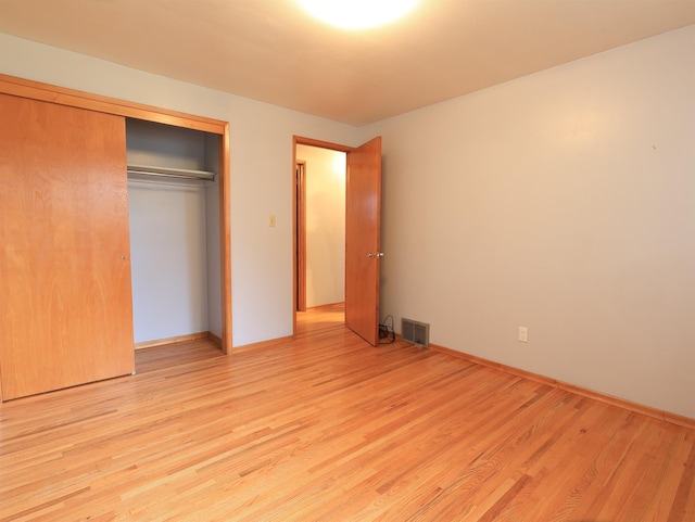 unfurnished bedroom featuring a closet and light wood-type flooring