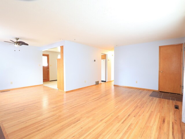 unfurnished living room featuring ceiling fan, a fireplace, and light wood-type flooring