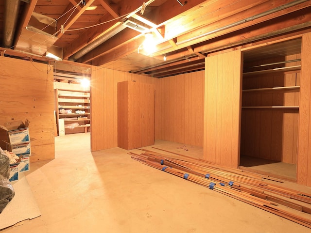 basement featuring wooden walls