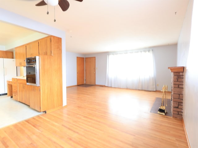 kitchen featuring ceiling fan, light hardwood / wood-style floors, and white fridge