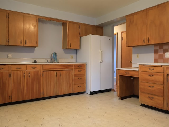 kitchen with tasteful backsplash, sink, and white refrigerator