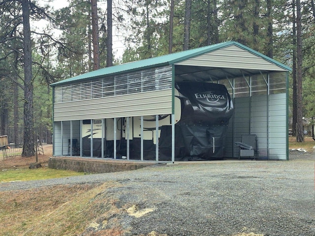 view of outbuilding with a detached carport and driveway