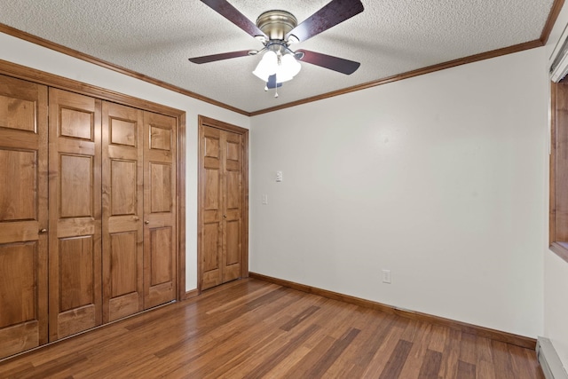 unfurnished bedroom with wood-type flooring, crown molding, ceiling fan, a baseboard heating unit, and a textured ceiling