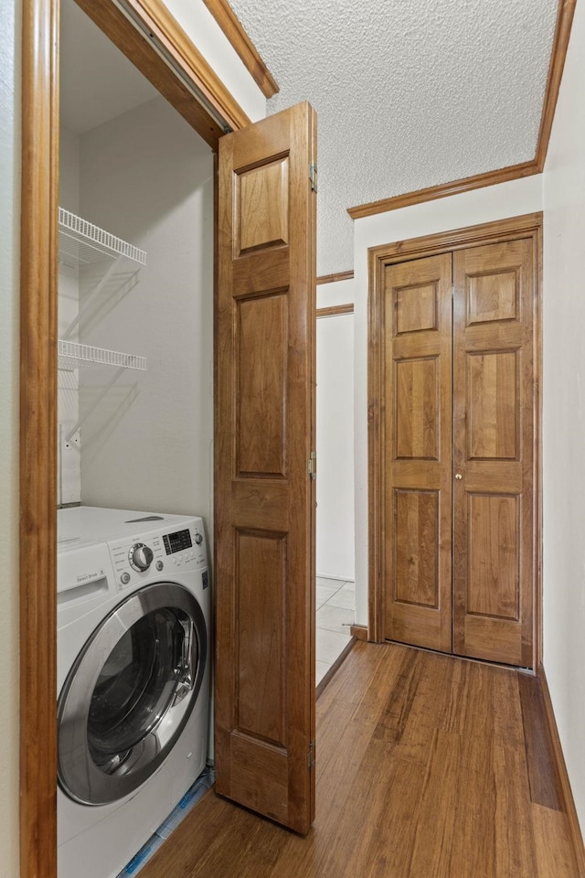 laundry room featuring a textured ceiling, washer / dryer, and dark hardwood / wood-style floors