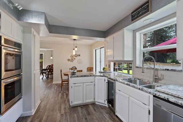 kitchen featuring stainless steel appliances, dark hardwood / wood-style flooring, white cabinetry, and sink