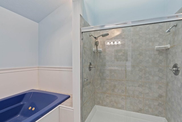 bathroom featuring independent shower and bath and a textured ceiling