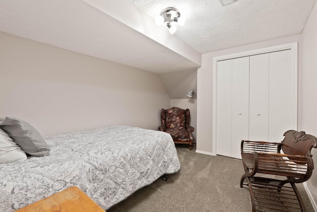 bedroom featuring a textured ceiling, carpet flooring, a closet, and vaulted ceiling