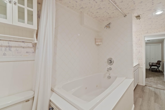 bathroom featuring toilet, a textured ceiling, wood-type flooring, and shower / tub combo with curtain