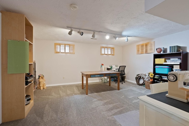 office with a textured ceiling, track lighting, and light carpet