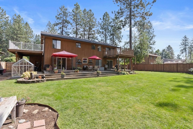 back of property with a patio, an outdoor structure, a yard, and a wooden deck