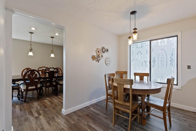 dining room featuring dark wood-type flooring and a textured ceiling