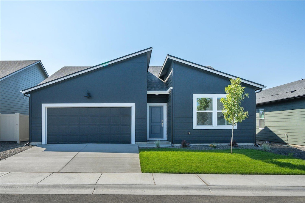 view of front of house featuring a garage and a front lawn