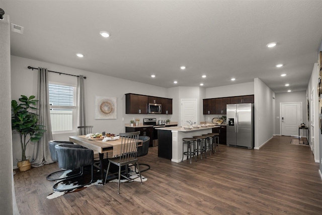 dining room with sink, dark hardwood / wood-style flooring, and a textured ceiling