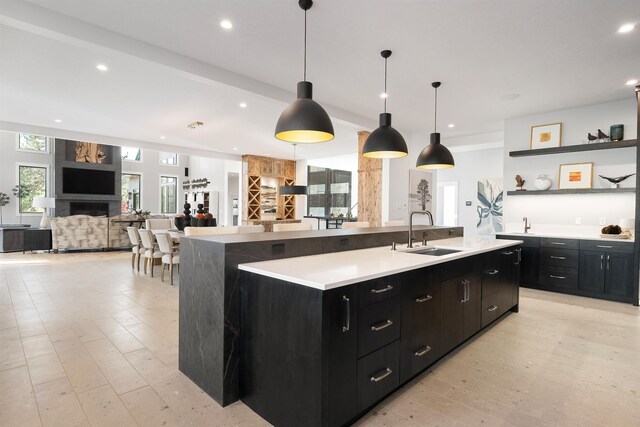 kitchen featuring a spacious island, light hardwood / wood-style floors, pendant lighting, and sink