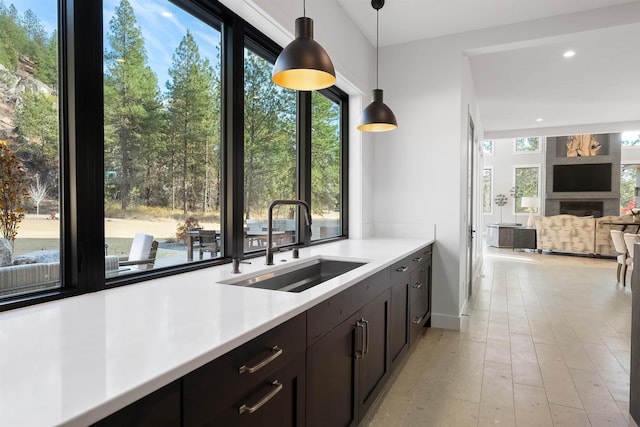 kitchen with sink, dark brown cabinets, and decorative light fixtures