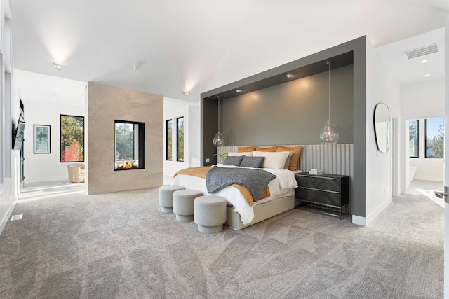 bedroom featuring light carpet and a high end fireplace