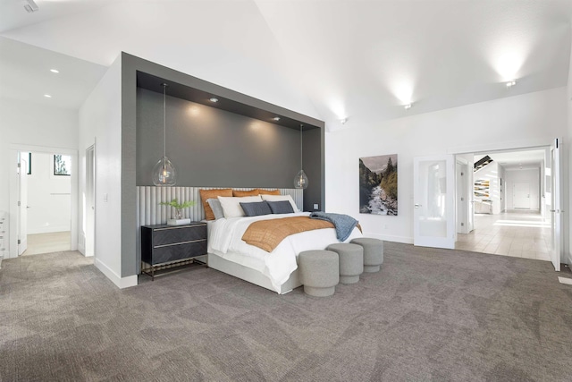 bedroom featuring ensuite bath, high vaulted ceiling, and carpet