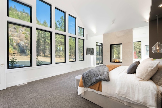 bedroom featuring a fireplace, high vaulted ceiling, and carpet floors