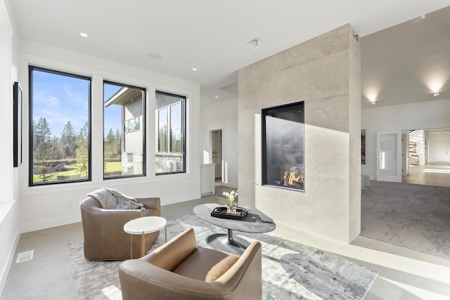 living area with a tiled fireplace and tile patterned floors