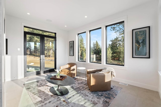 sitting room featuring french doors and light tile patterned flooring