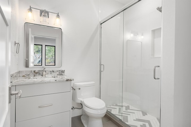 bathroom with toilet, an enclosed shower, and vanity