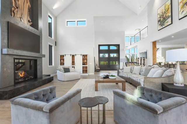 living room with a towering ceiling and light wood-type flooring