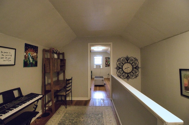 corridor with hardwood / wood-style flooring and lofted ceiling