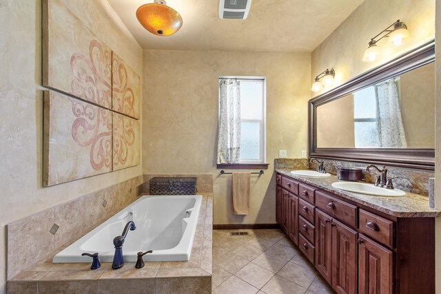 bathroom with vanity, tile patterned floors, and a relaxing tiled tub