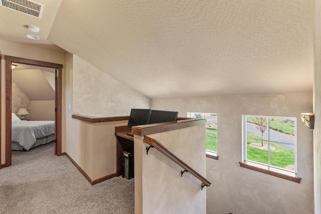 staircase with lofted ceiling, a textured ceiling, and carpet floors