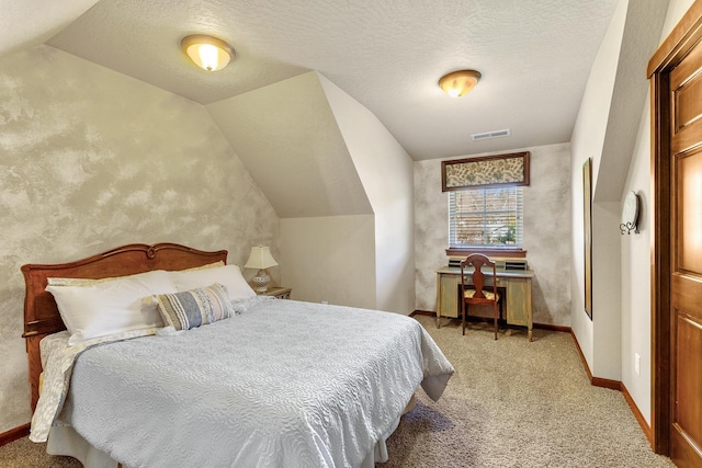 bedroom with a textured ceiling, vaulted ceiling, and light colored carpet