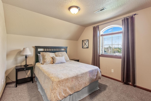 carpeted bedroom featuring a textured ceiling and vaulted ceiling