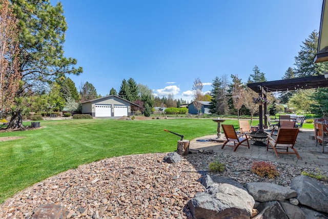 view of yard with an outdoor fire pit, a patio area, a garage, and an outdoor structure