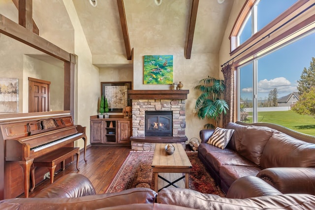 living room with beamed ceiling, high vaulted ceiling, dark hardwood / wood-style flooring, and a stone fireplace