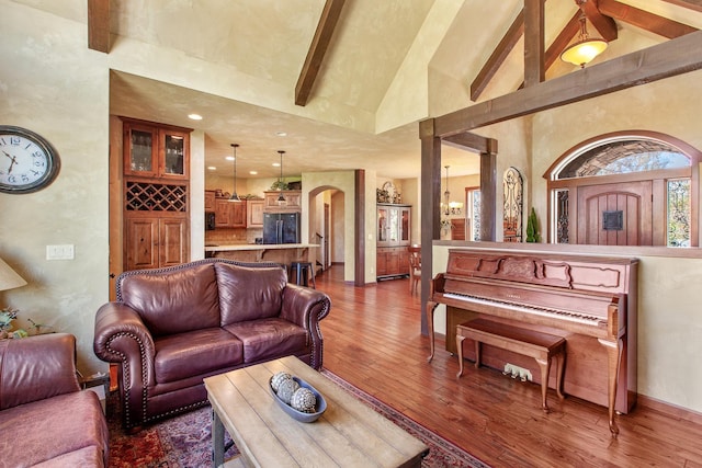 living room featuring high vaulted ceiling, a chandelier, and wood-type flooring